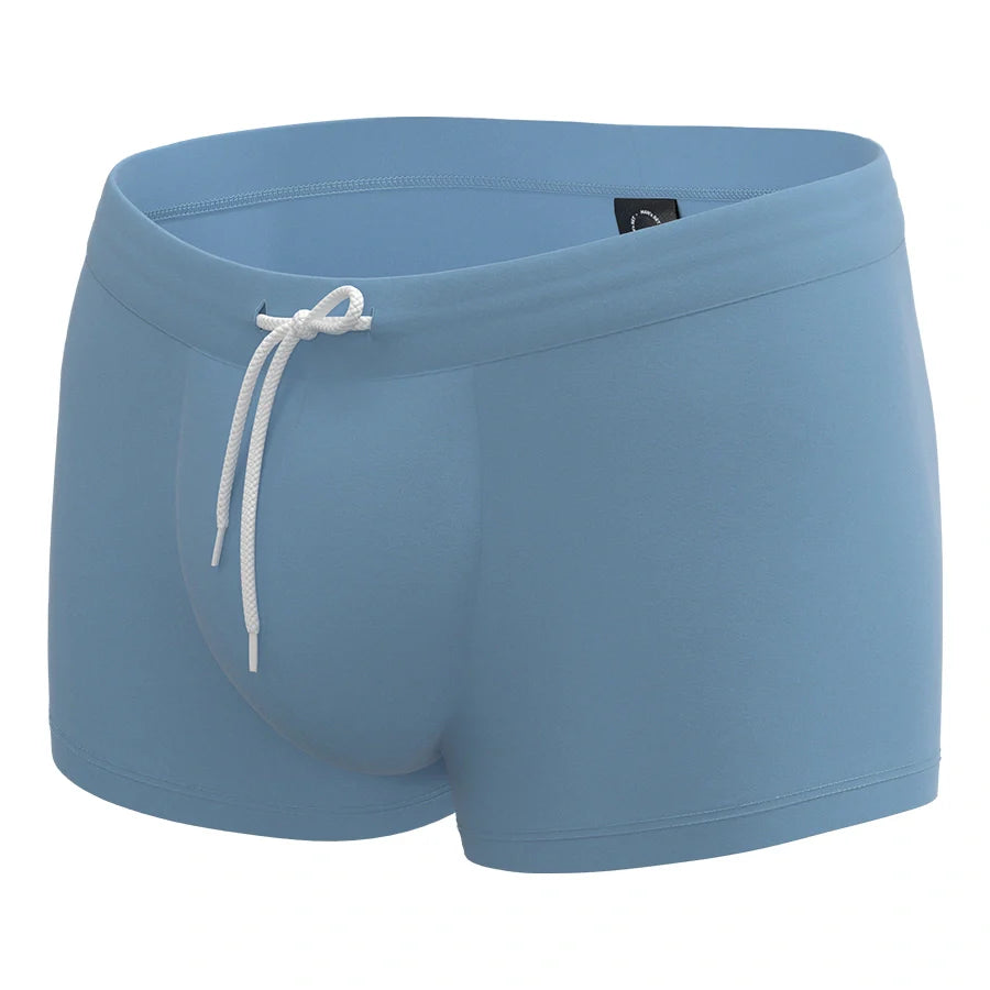 Light gray anatomical men’s swim trunks by Man’s SET, supportive pouch design, angled view